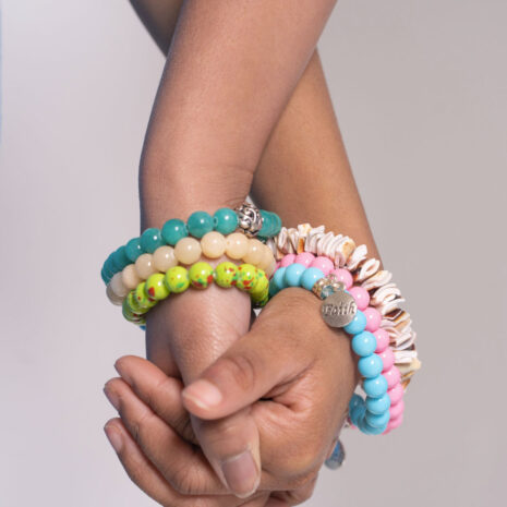 About Life Faith Love – An image of two people hold hands modeling beaded gemstone bracelets.